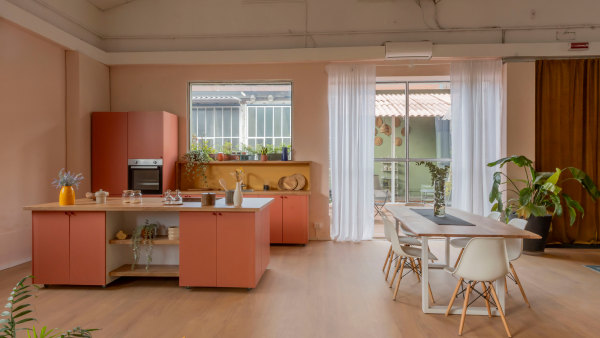 La cucina a isola del loft con le ante rosa La cucina a isola del loft con le ante rosa