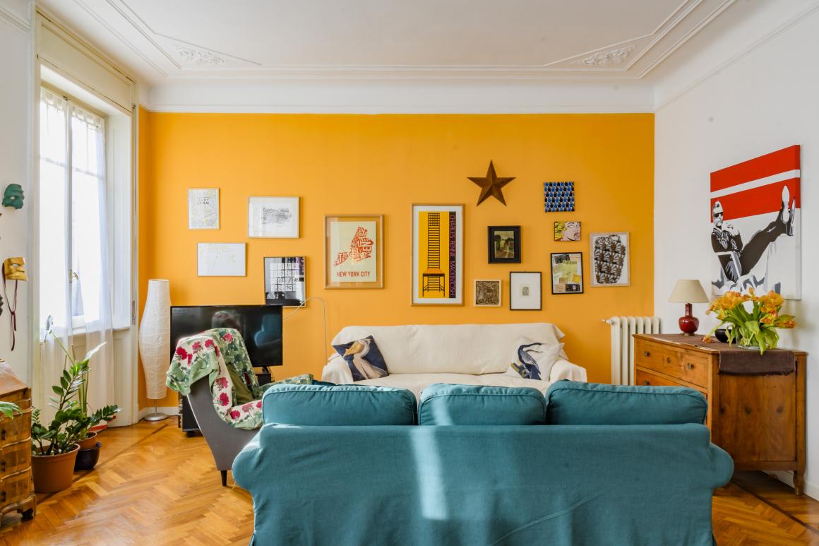 Zona living con parete gialla