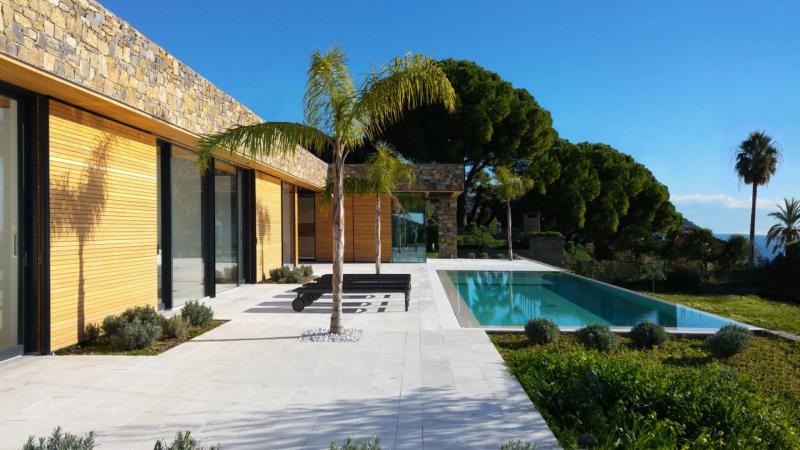 piscina con vista sul mare e casa in pietra e legno