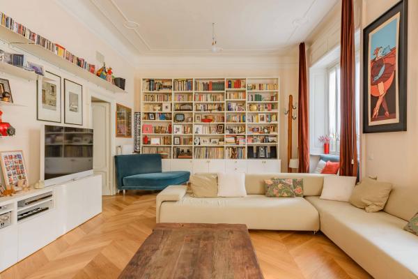 Libreria e parquet a spina in soggiorno luminoso a Milano