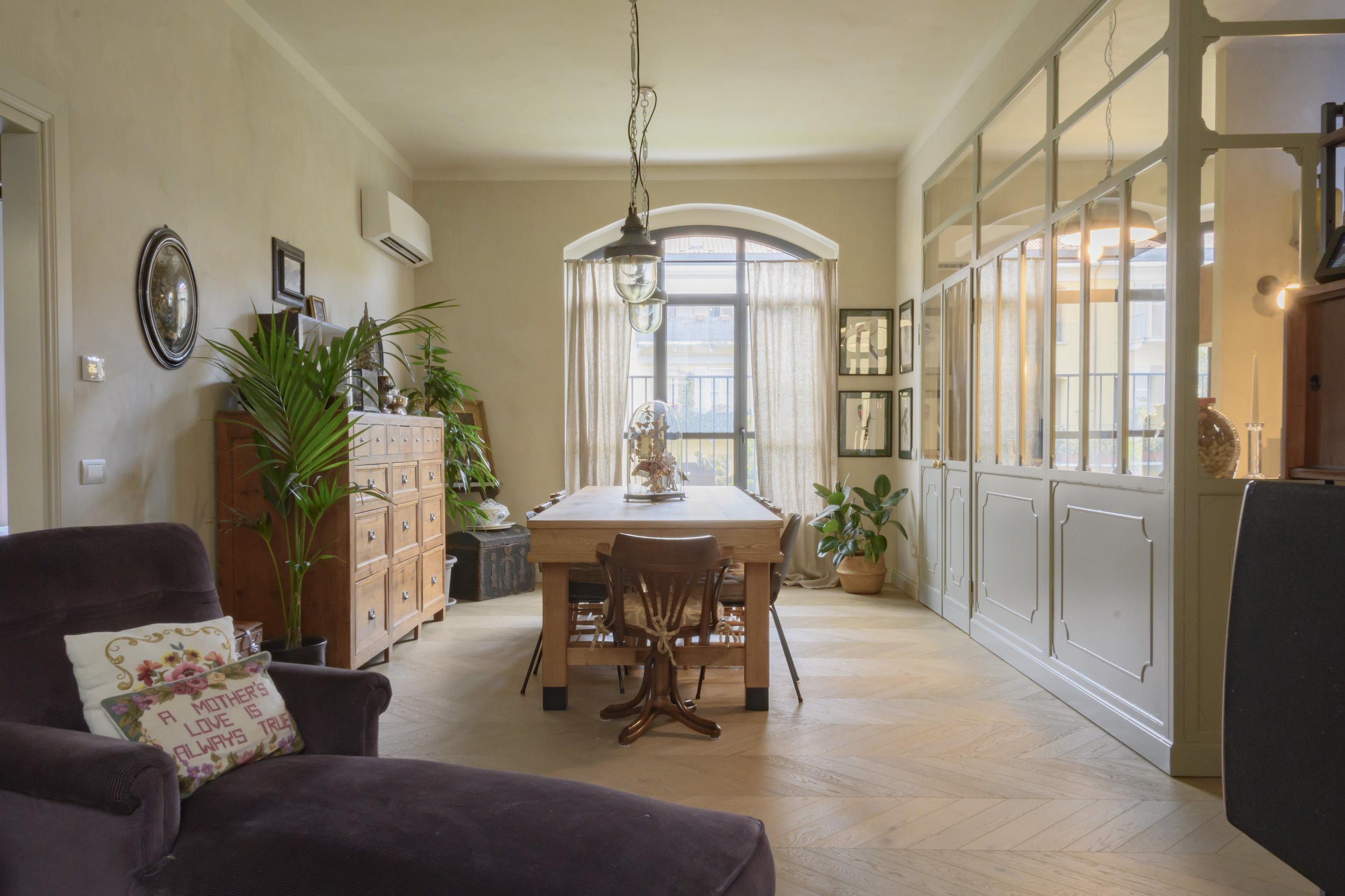 Zona living con finestra ad arco e vetrata vintage