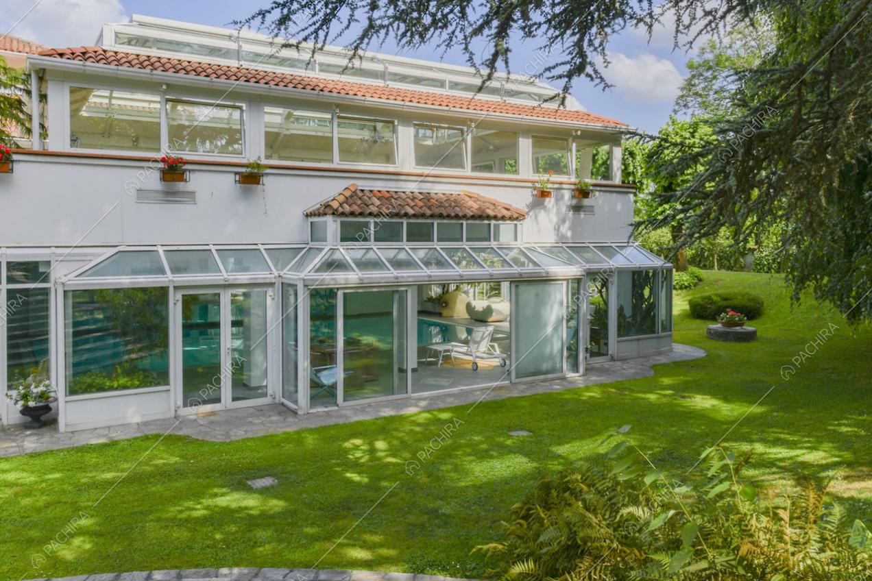 Vista dal giardino sulla piscina al chiuso tramite le ampie vetrate