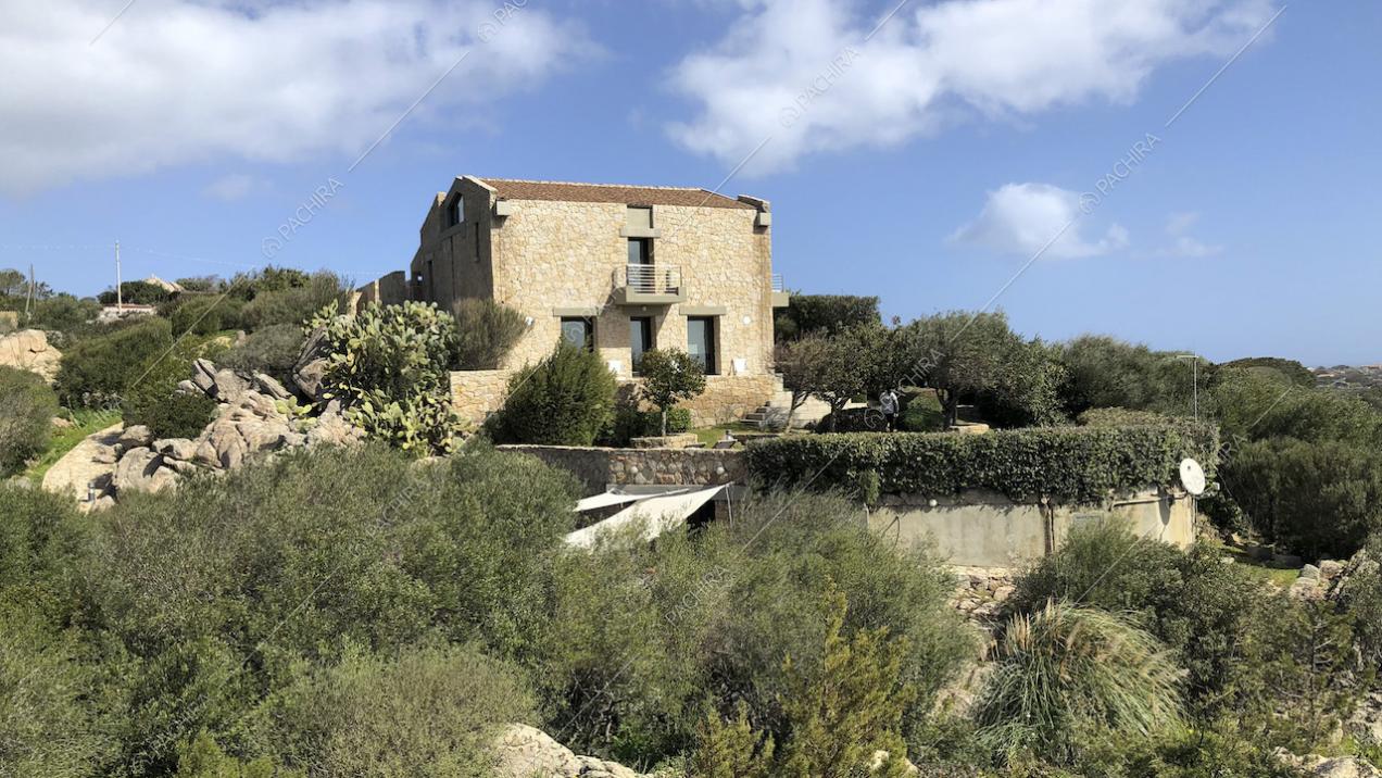 Villa con pareti in pietra immersa nella vegetazione sarda