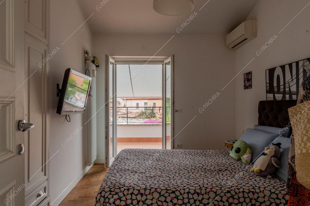 Camera da letto con porta finestra della villa Pino Mugo, location in stile moderno a Roma