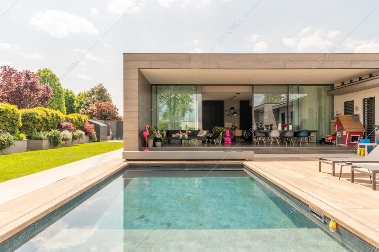 Dalla piscina vista sulla zona living attraverso le ampie porte-finestre scorrevoli