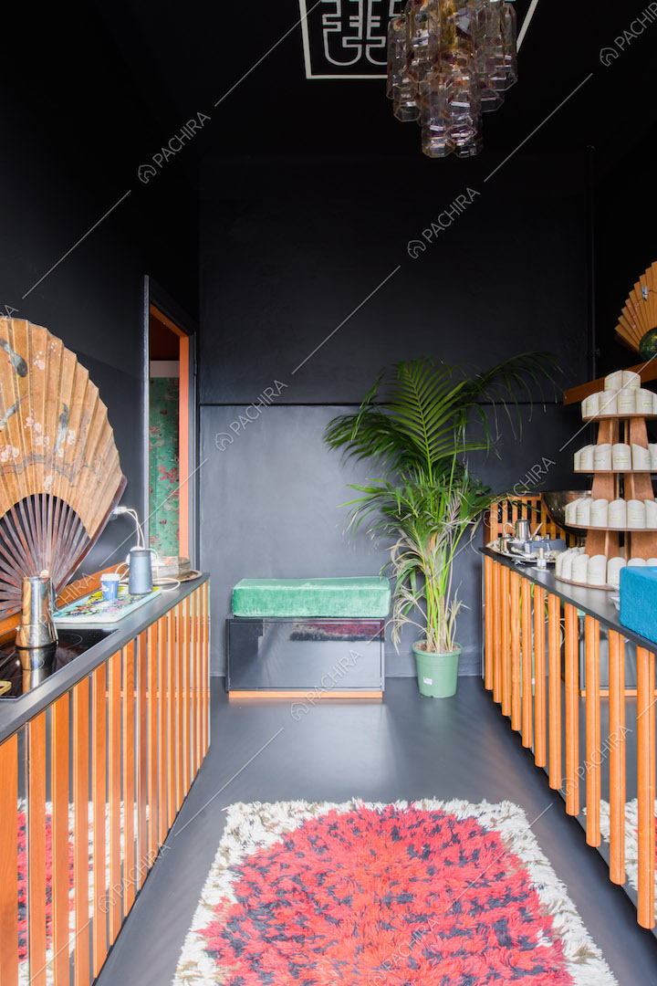 Luminosa cucina a parete total black con fornelli a induzione e sportelli con specchi e assi di legno