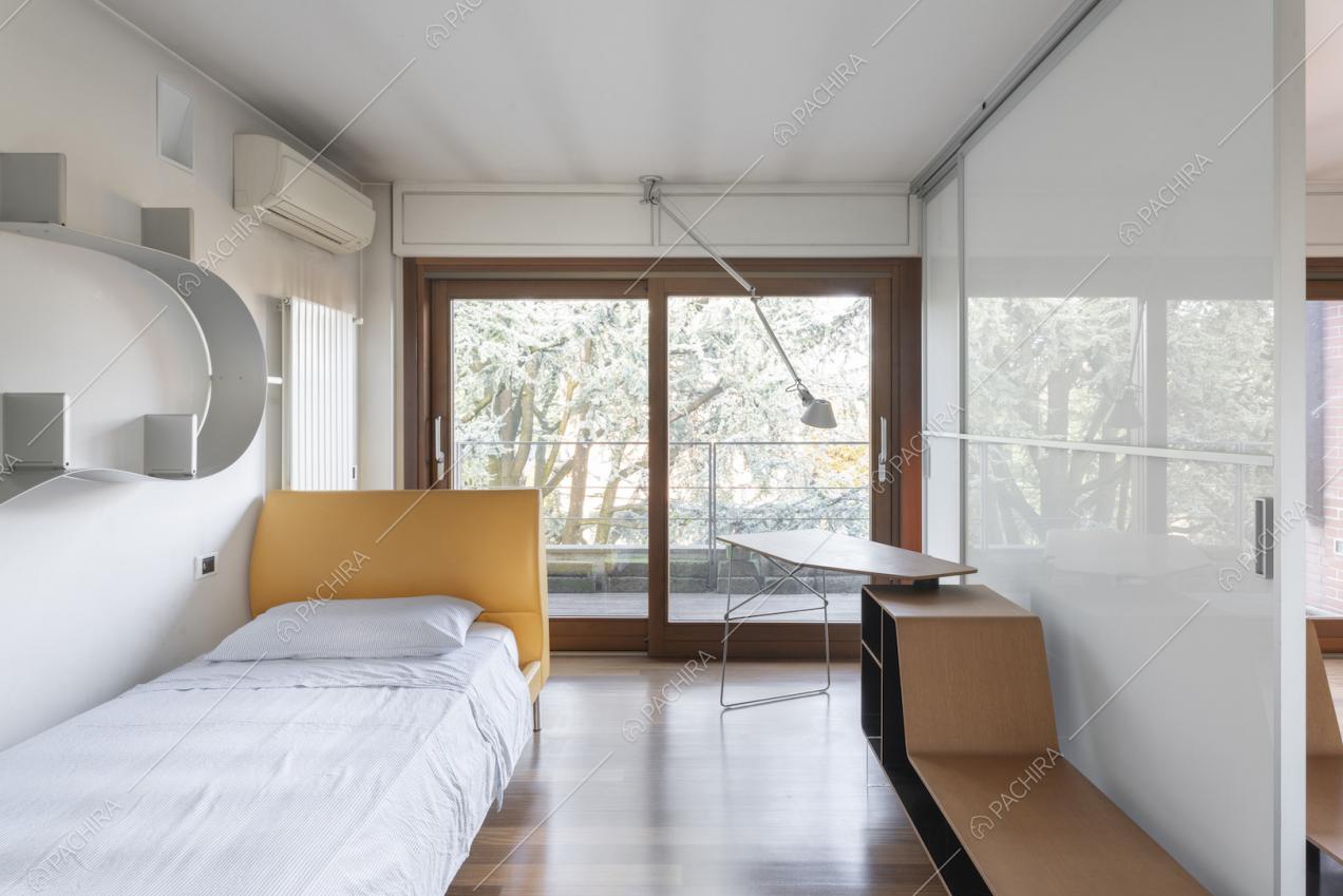Camera con letto e libreria di design appesa alla parete