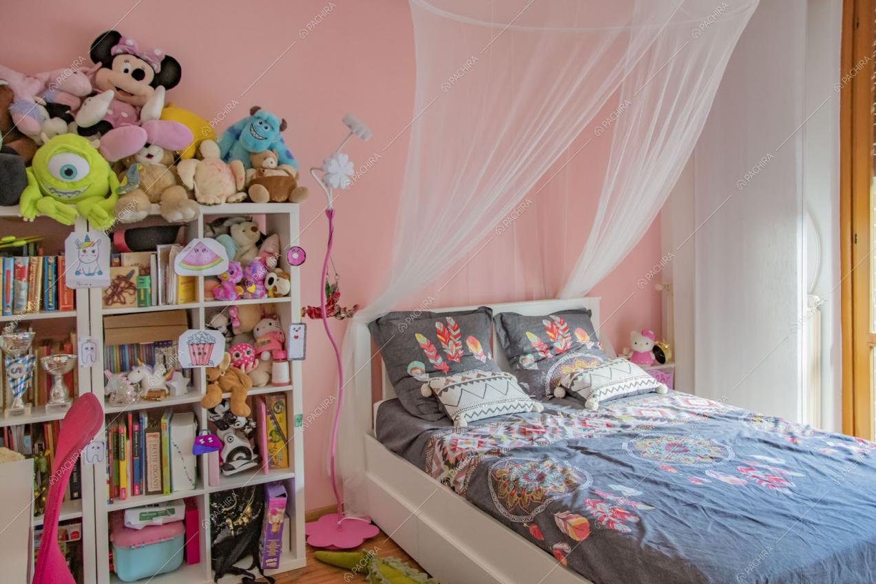 Camera da letto dei bambini con parete rosa e pavimento in parquet