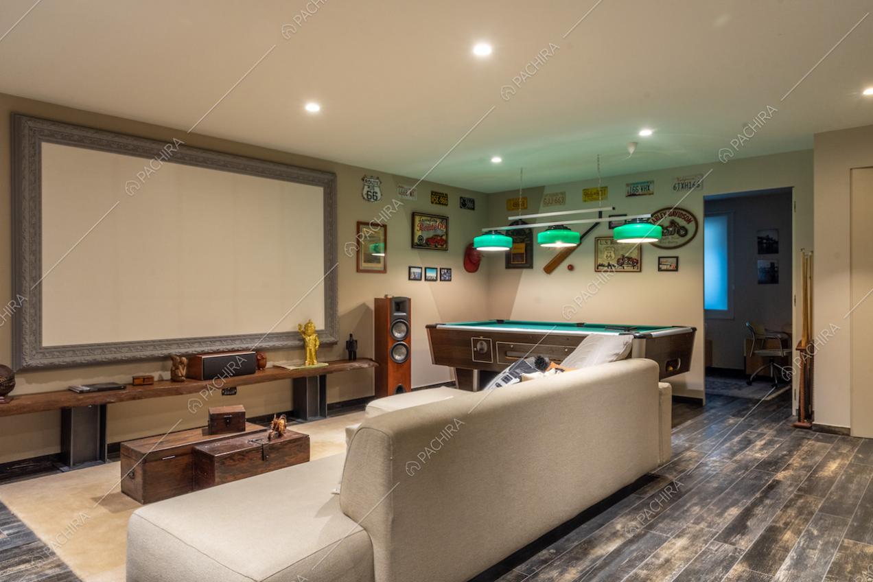 Sala cinema con biliardo, impianto stereo, divano bianco e pavimento in parquet