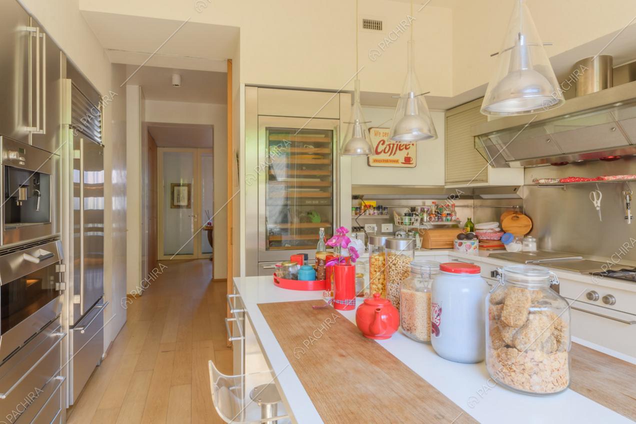 Cucina a isola con cantinetta, fornelli a gas e pavimento in parquet