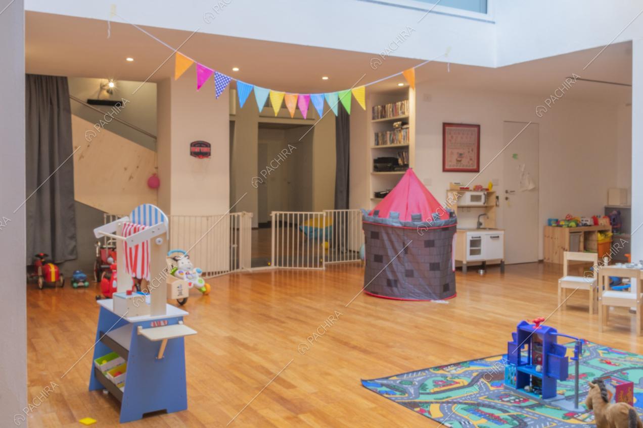 Giochi per bambini sul pavimento in parquet e faretti sul suffitto
