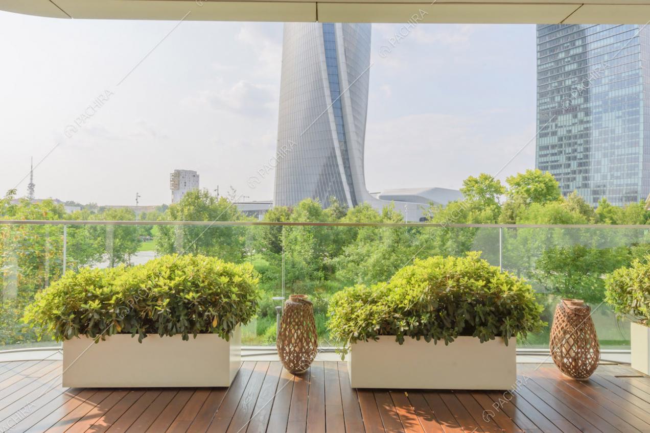 Vista sullo skyline dalla terrazza con parapetto in vetro e pavimentazione in parquet