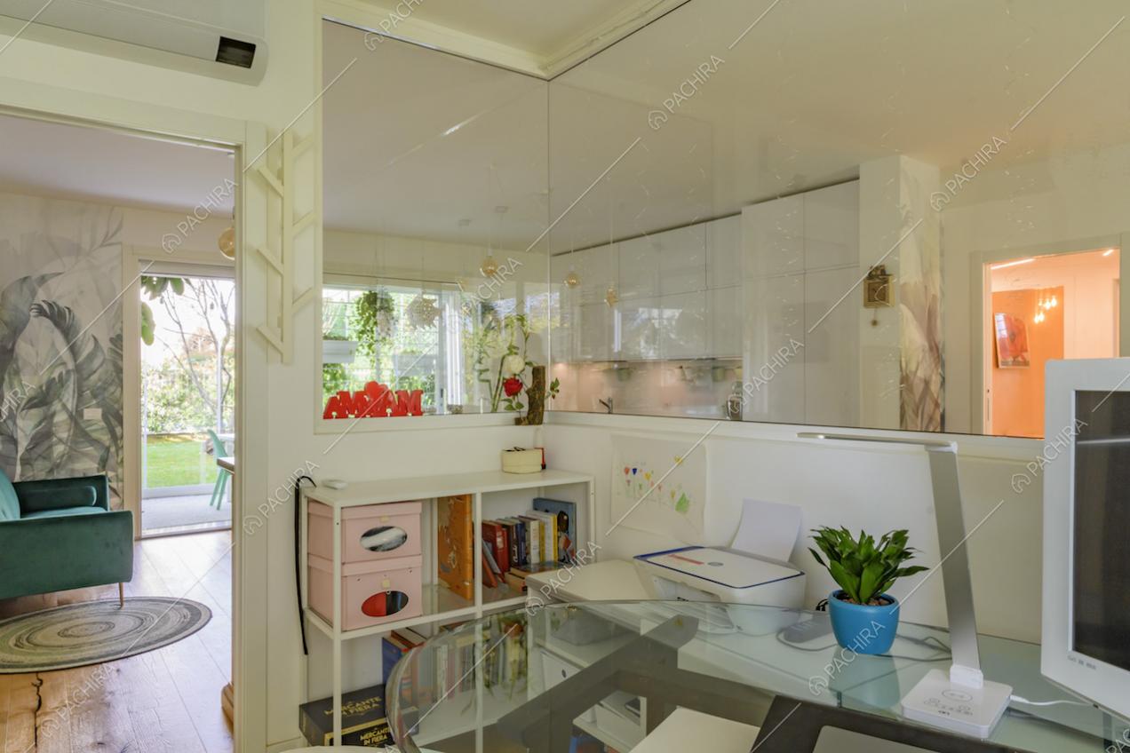 Dallo studio vista su salotto e cucina tramite una vetrata