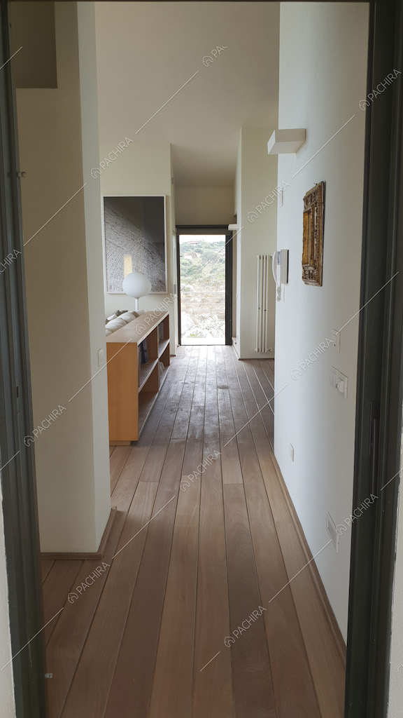 Corridoio con pareti bianche e parquet chiaro