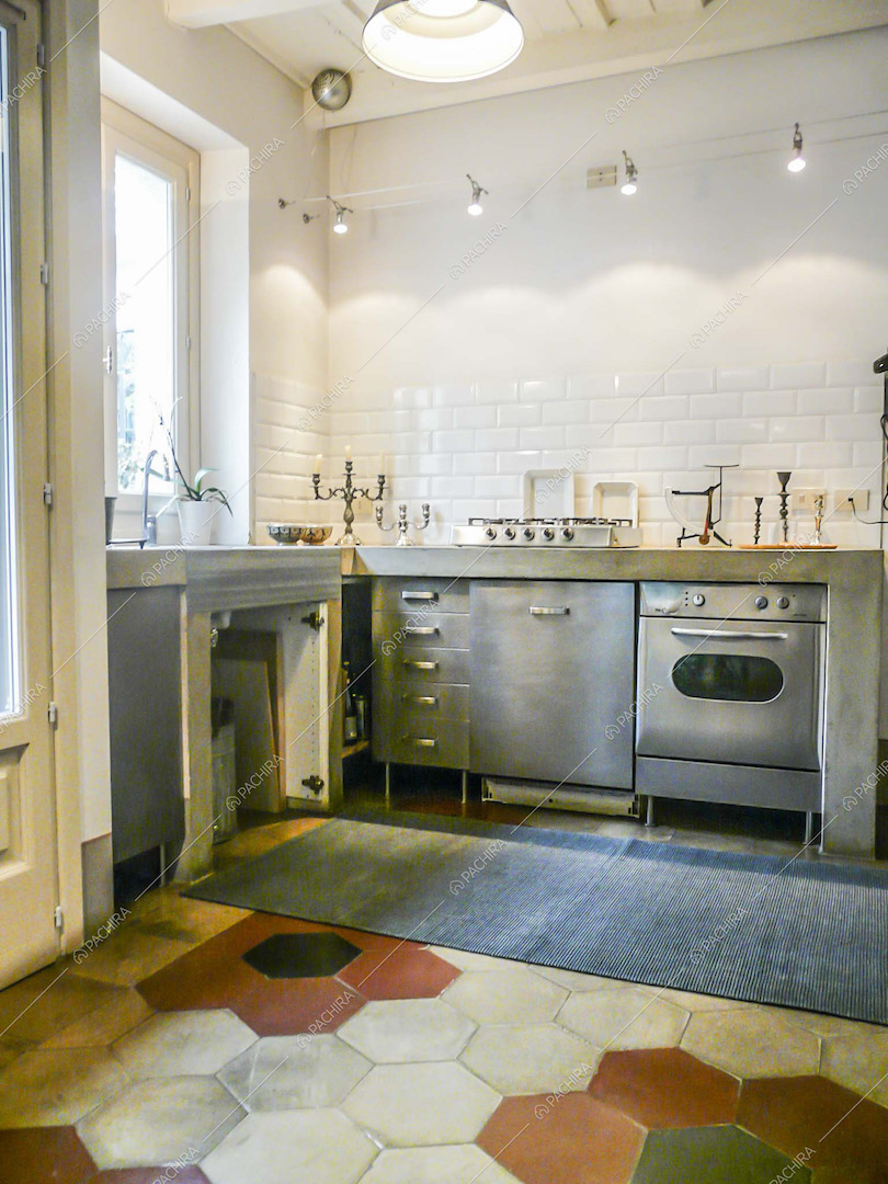 Cucina a parete in acciaio, pavimento in cementine e paraschizzi in piastrelle bianche