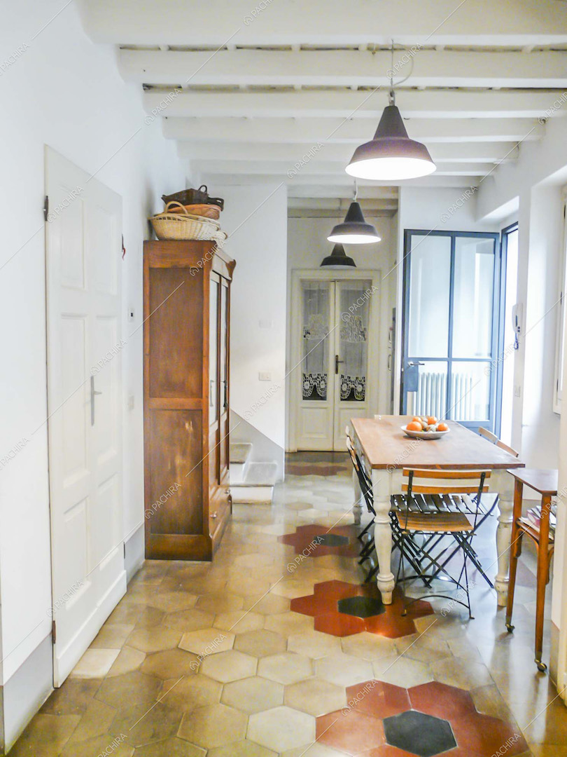 Sala con pavimento in cementine, pareti bianche e tavolo da pranzo in legno