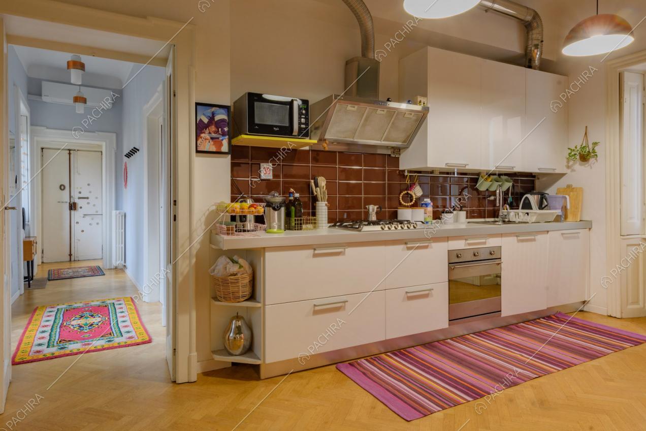 Cucina a parete con paraschizzi in piastrelle marroni e pavimento in parquet a spina di pesce