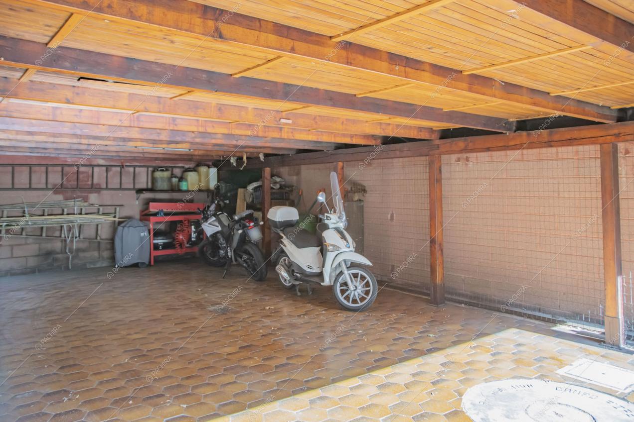 Grande garage con pavimento in cementine e soffitto in travi a vista