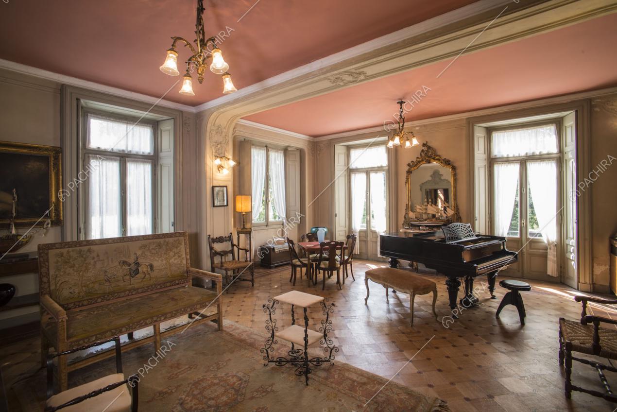 Zona living con divano d'epoca e pianoforte a mezza coda