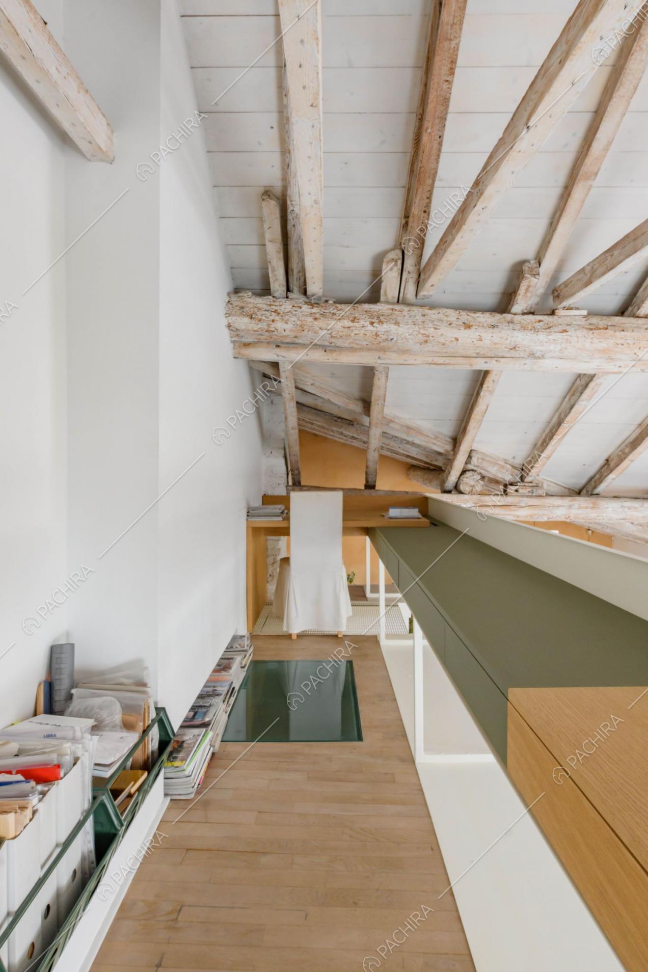 Sul soppalco studio con pavimento in parquet e scrivania arancione