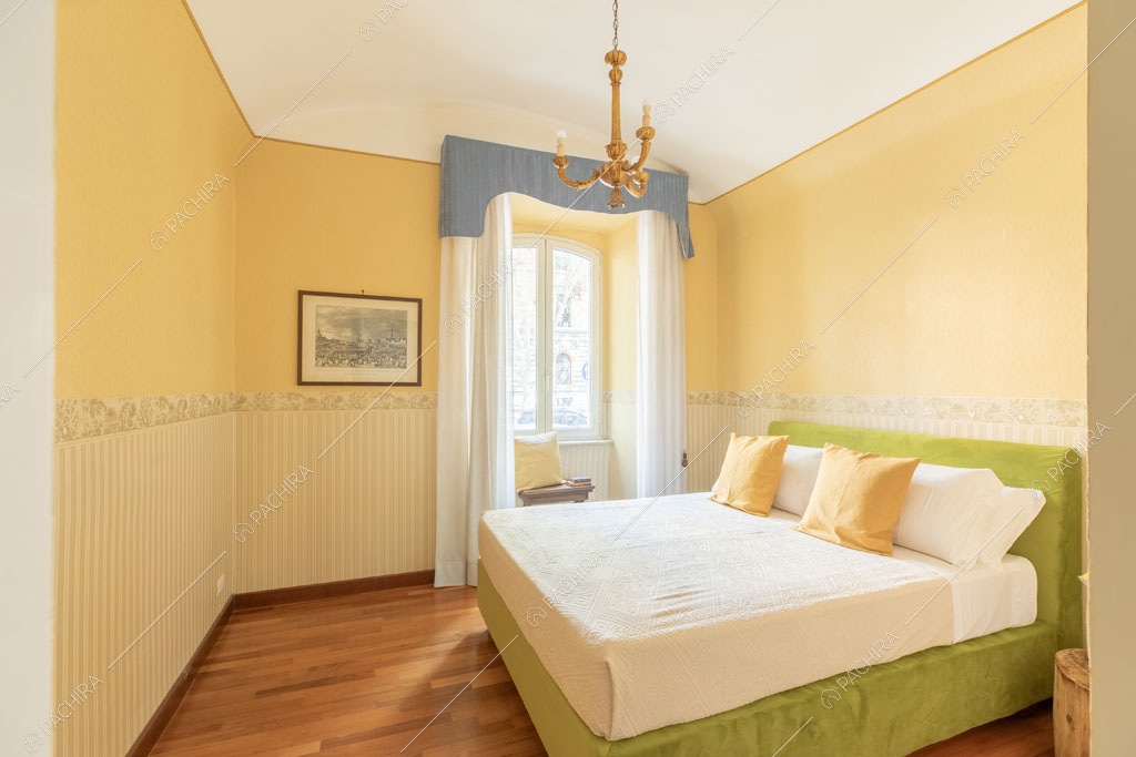 Camera da letto matrimoniale con carta da parati dell'appartamento Crescione, location in stile contemporaneo a Roma