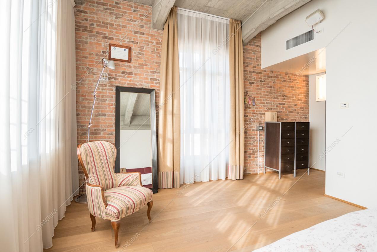 Vista dall'angolo della camera da letto su parete in mattoni rossi
