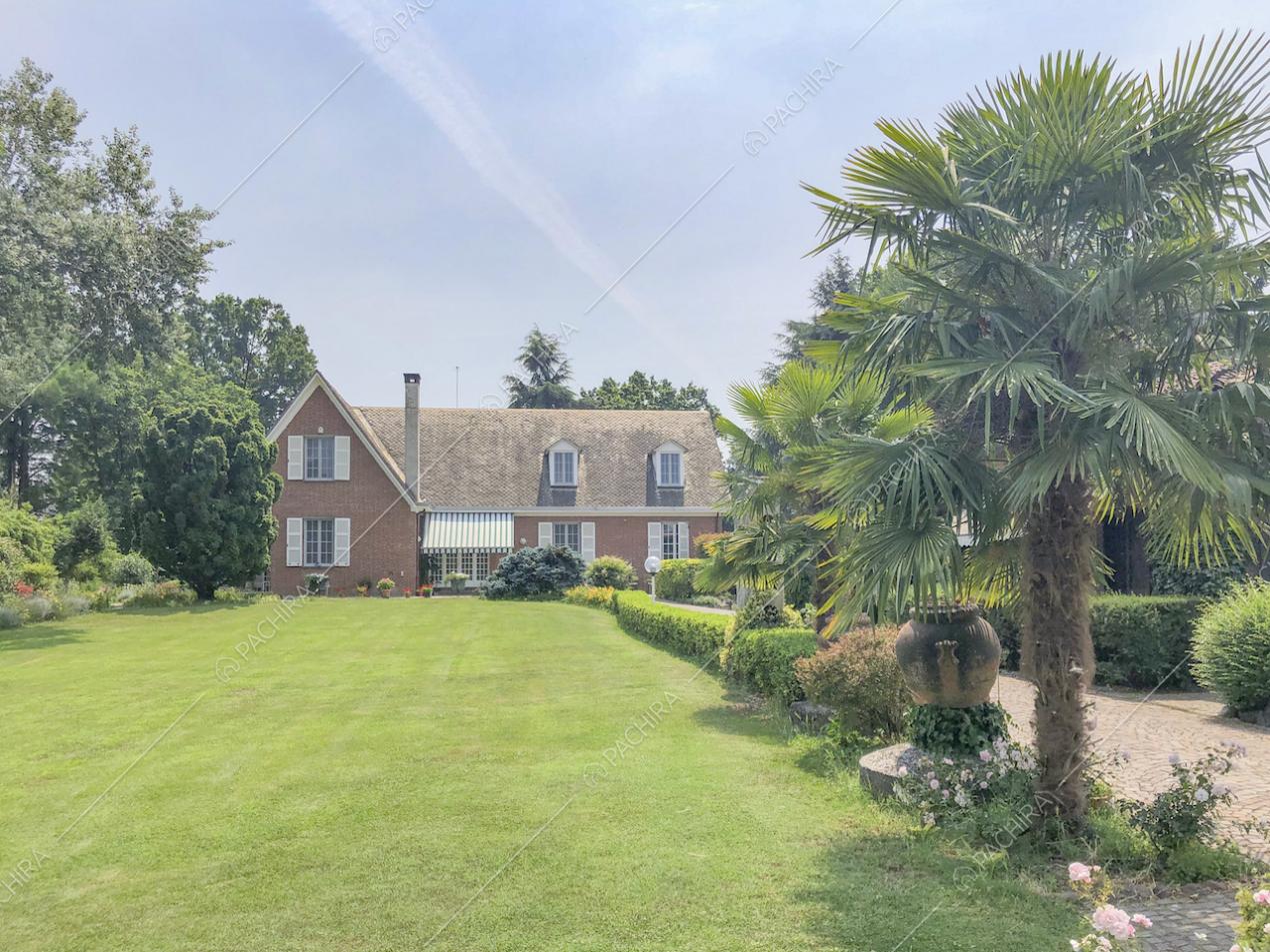 Prato davanti alla villa in stile inglese e palme