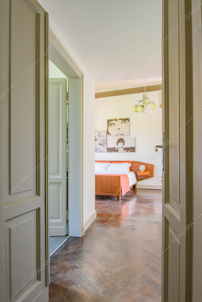 Pavimento in parquet a spina di pesce nella luminosa camera da letto matrimoniale