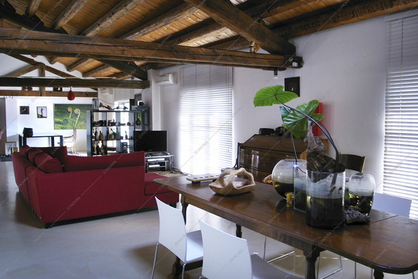 Zona living con tavolo in legno e divano rosso