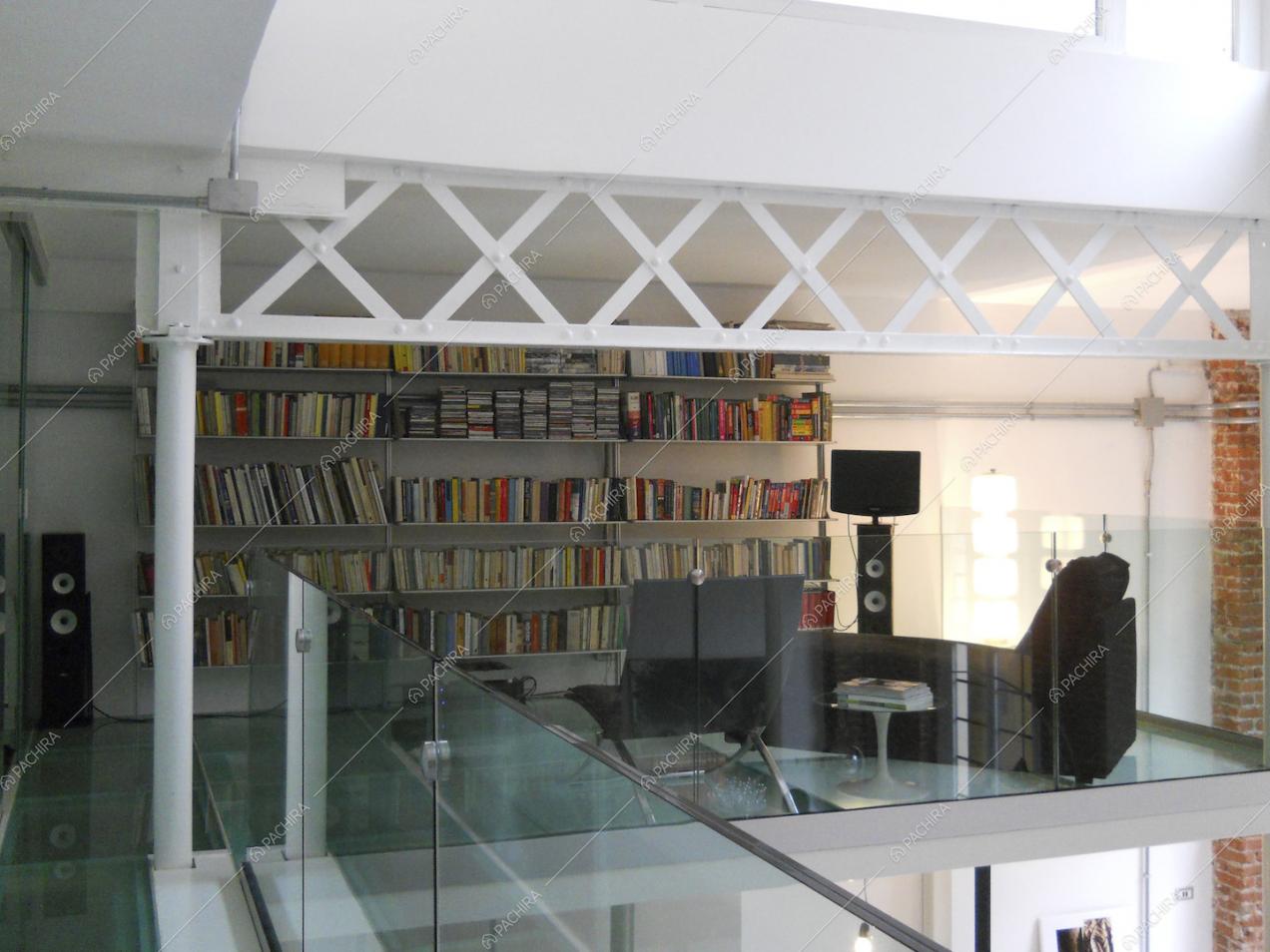 Sul soppalco biblioteca con balaustra e pavimento in vetro