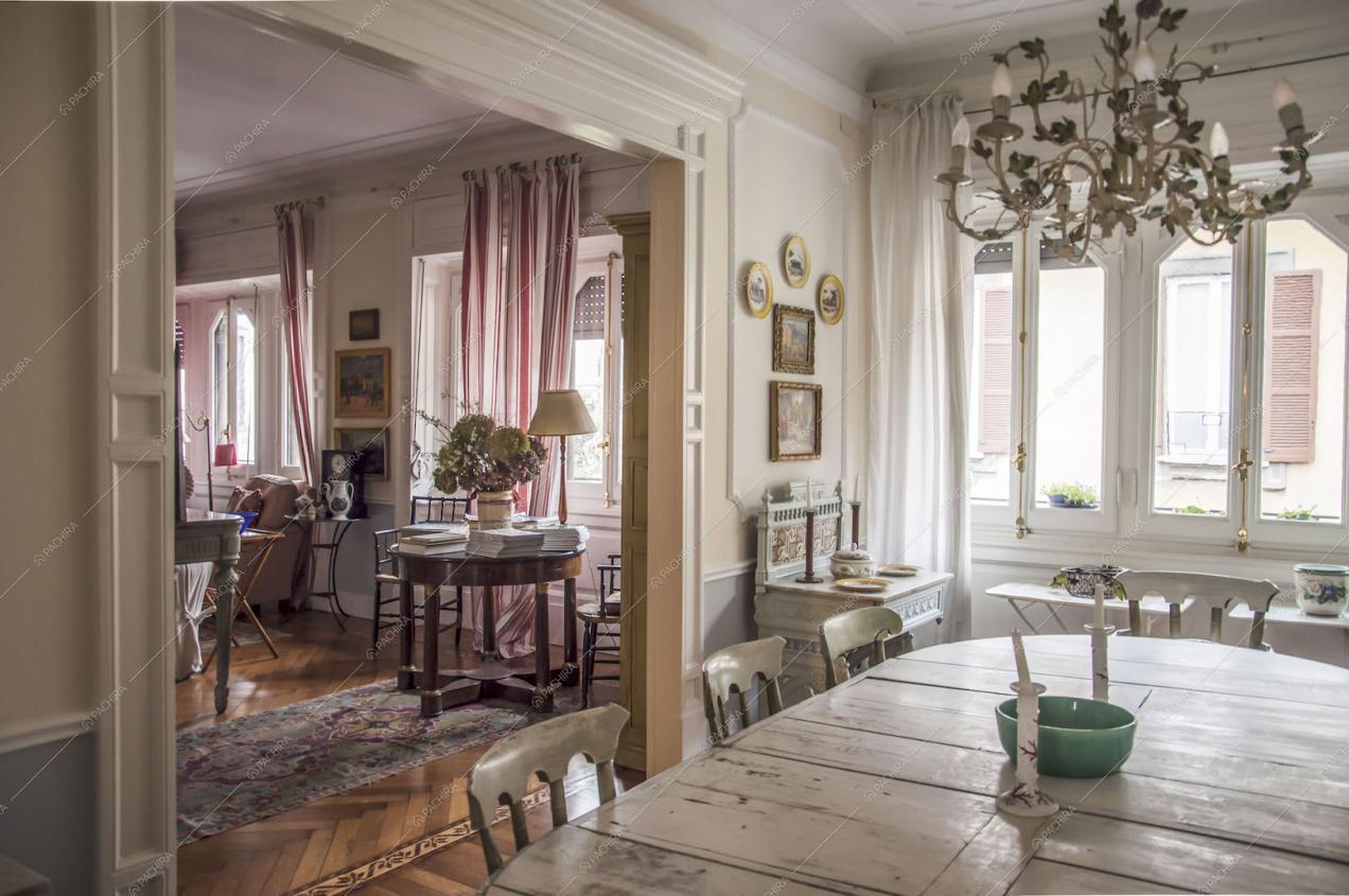 Pareti con boiserie, lampadario e tavolo da pranzo