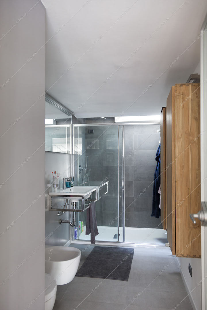 Bagno grigio con box doccia e sanitari sospesi