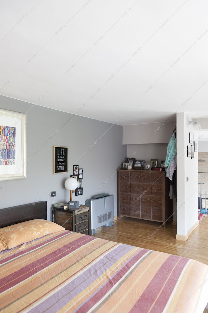 Camera da letto con cassettiera e pavimento in parquet