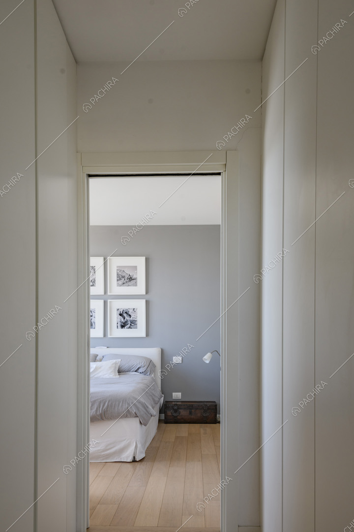 Camera da letto con parete color pastello e parquet
