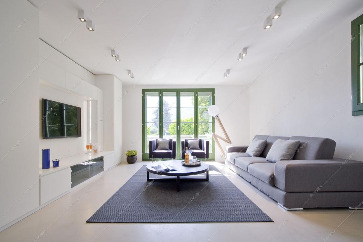 Zona living con divano, poltrone e vetrata