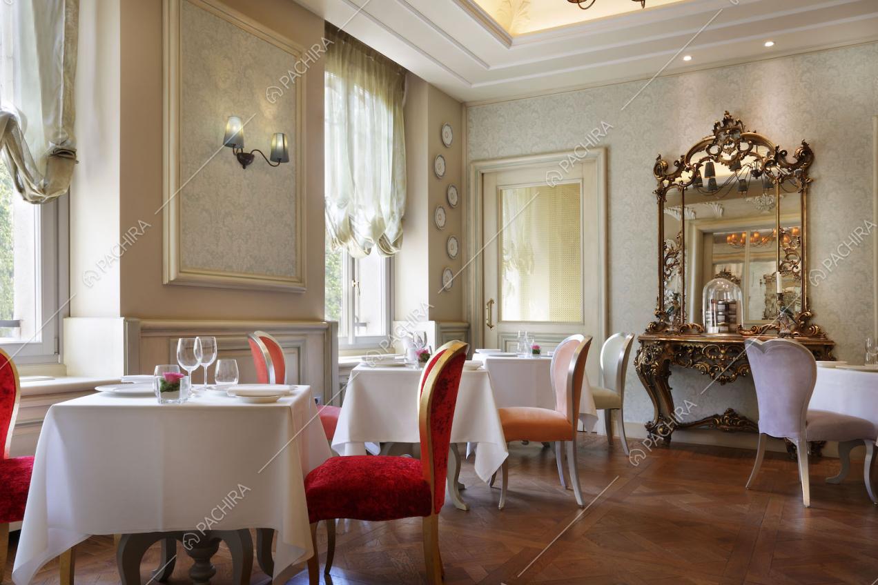 Sedie colorate e specchiera rococò nella sala da pranzo