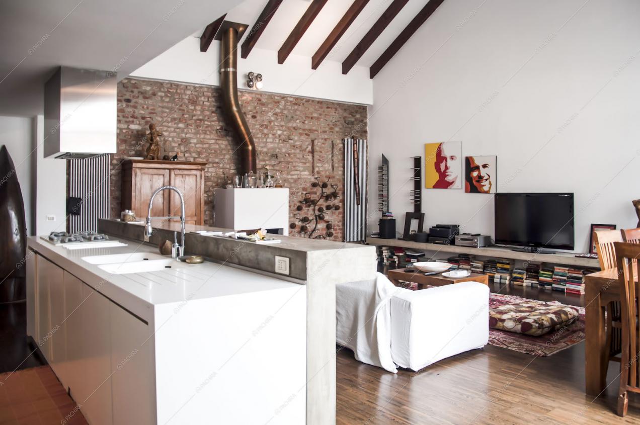 Isola della cucina con banco bar in cemento lisciato