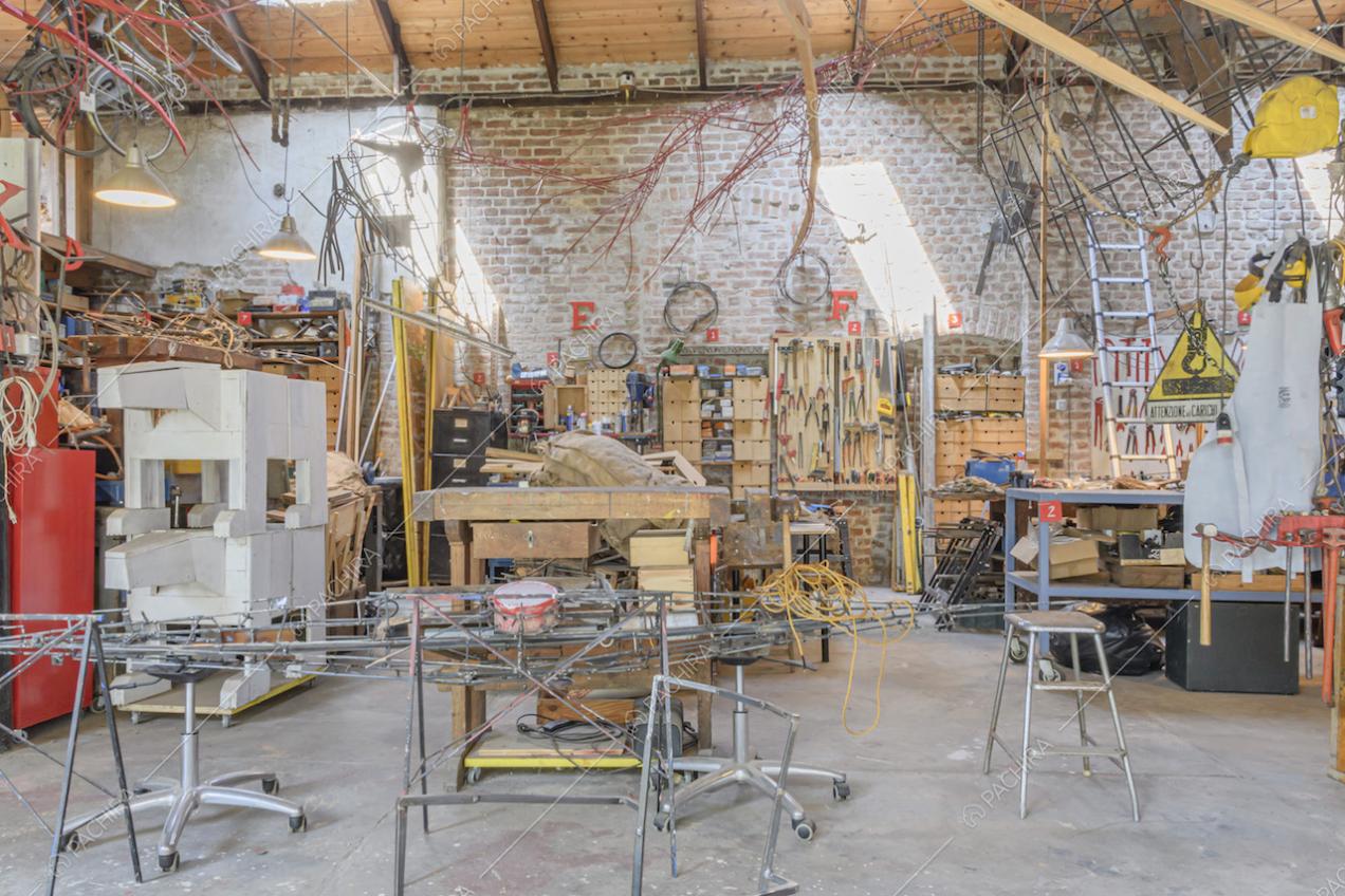 Officina con scaffalature, sgabelli e utensili