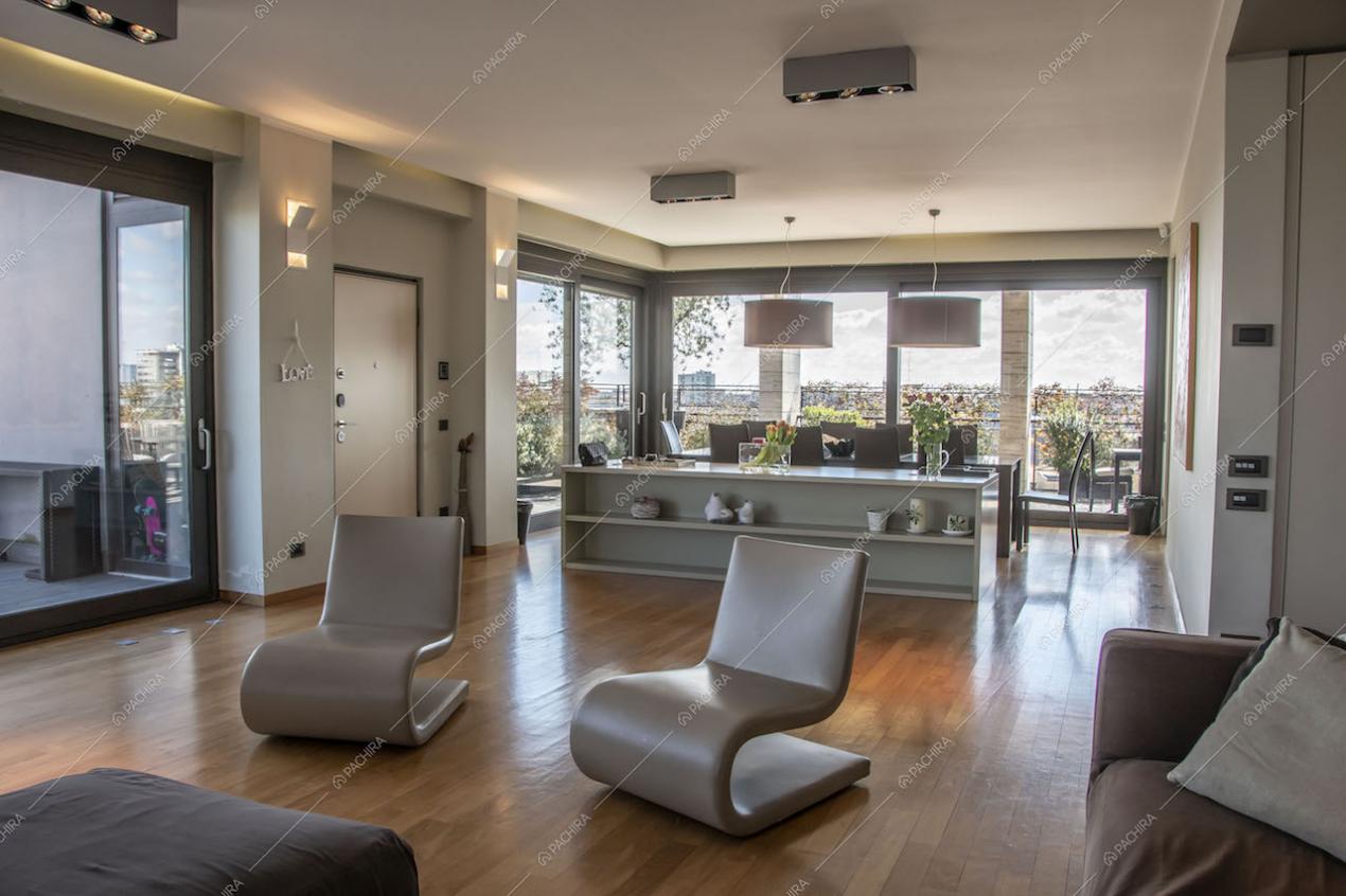 Poltrone di design nel salotto della location e vista panoramica grazie alle ampie vetrate