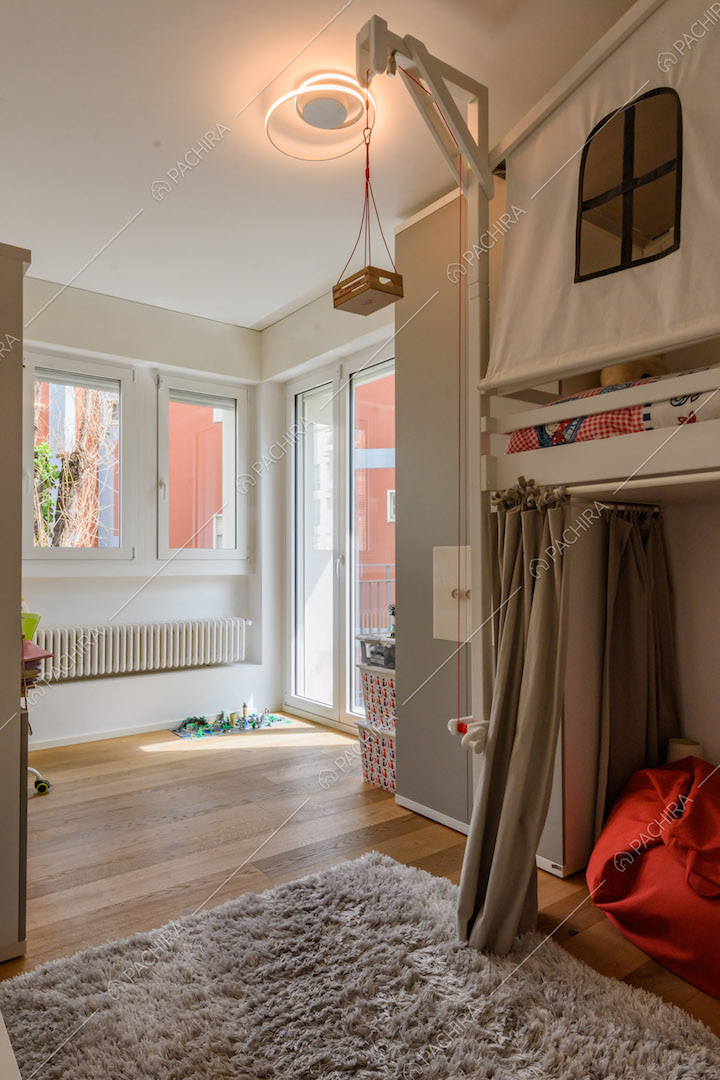 Camera da letto dei bambini con pavimento in parquet e porta-finestra