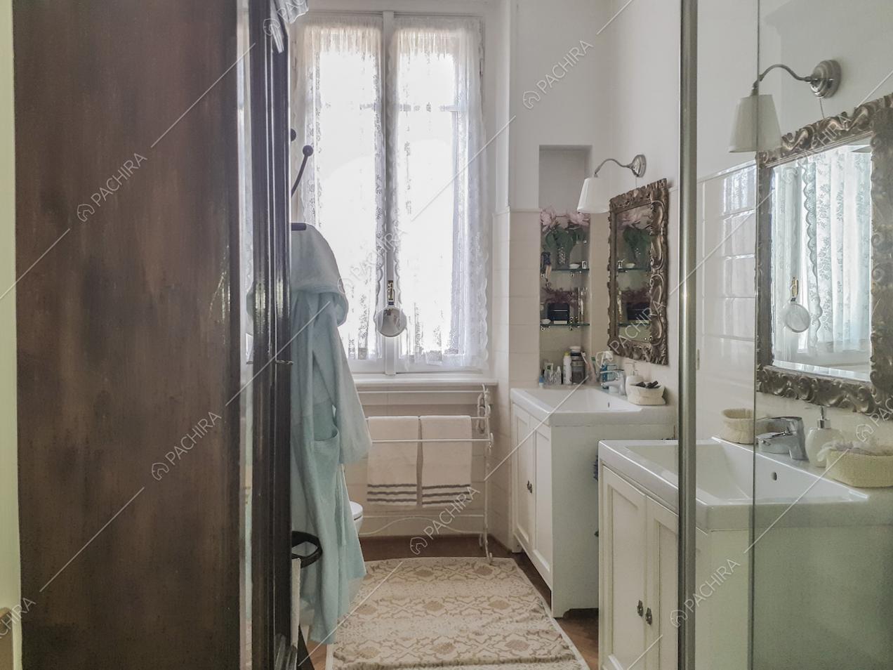 Bagno con due lavandini separati, specchi e lampade da parete