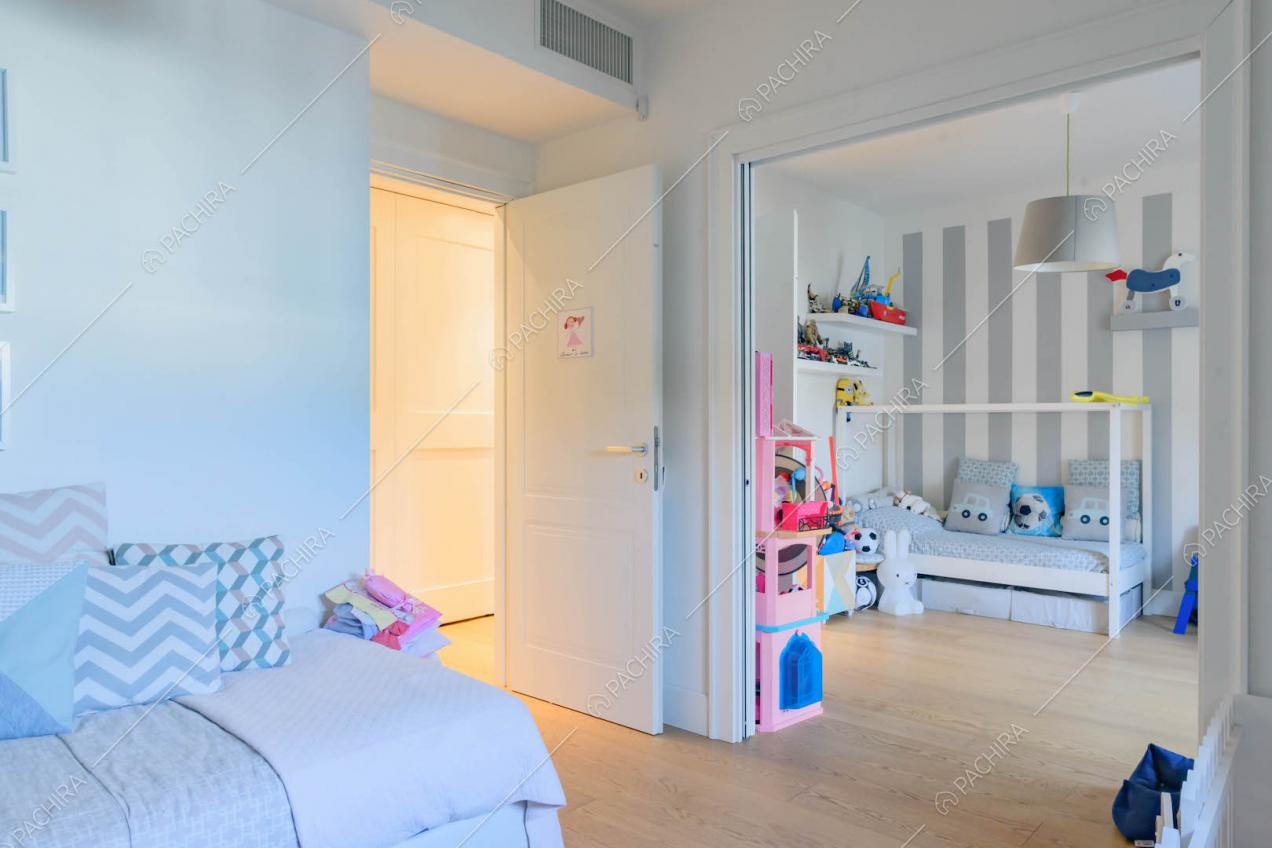 Camere da letto dei bambini comunicanti separati da porte bianche scorrevoli