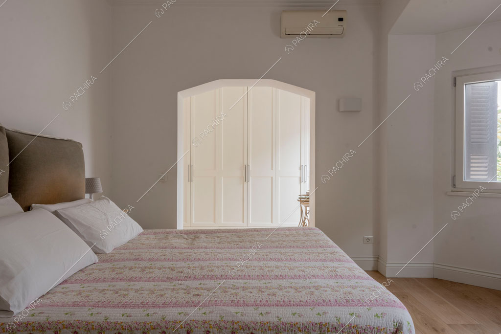 Camera da letto matrimoniale con pareti bianche della villa Pino Mugo, location in stile moderno a Roma