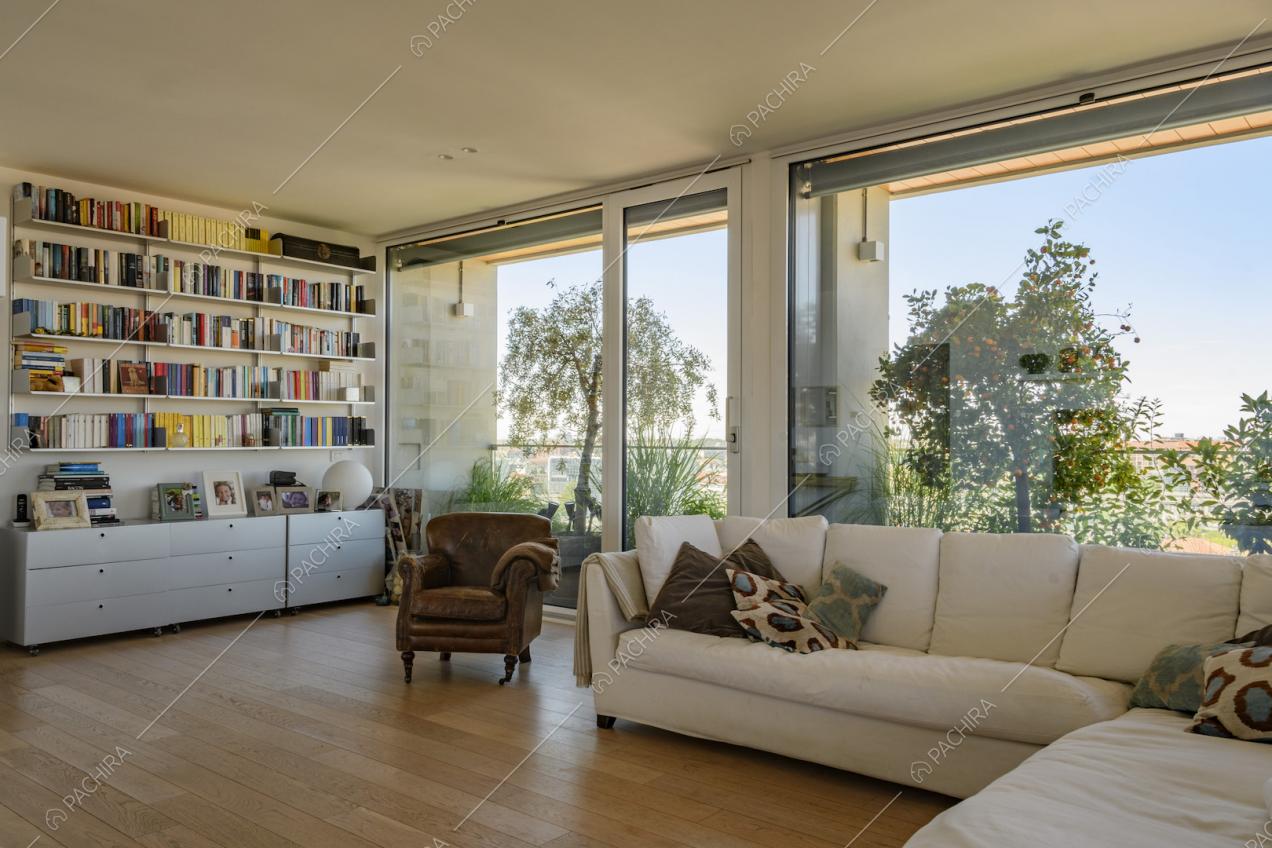 Poltrona vintage, divano e libreria in salotto
