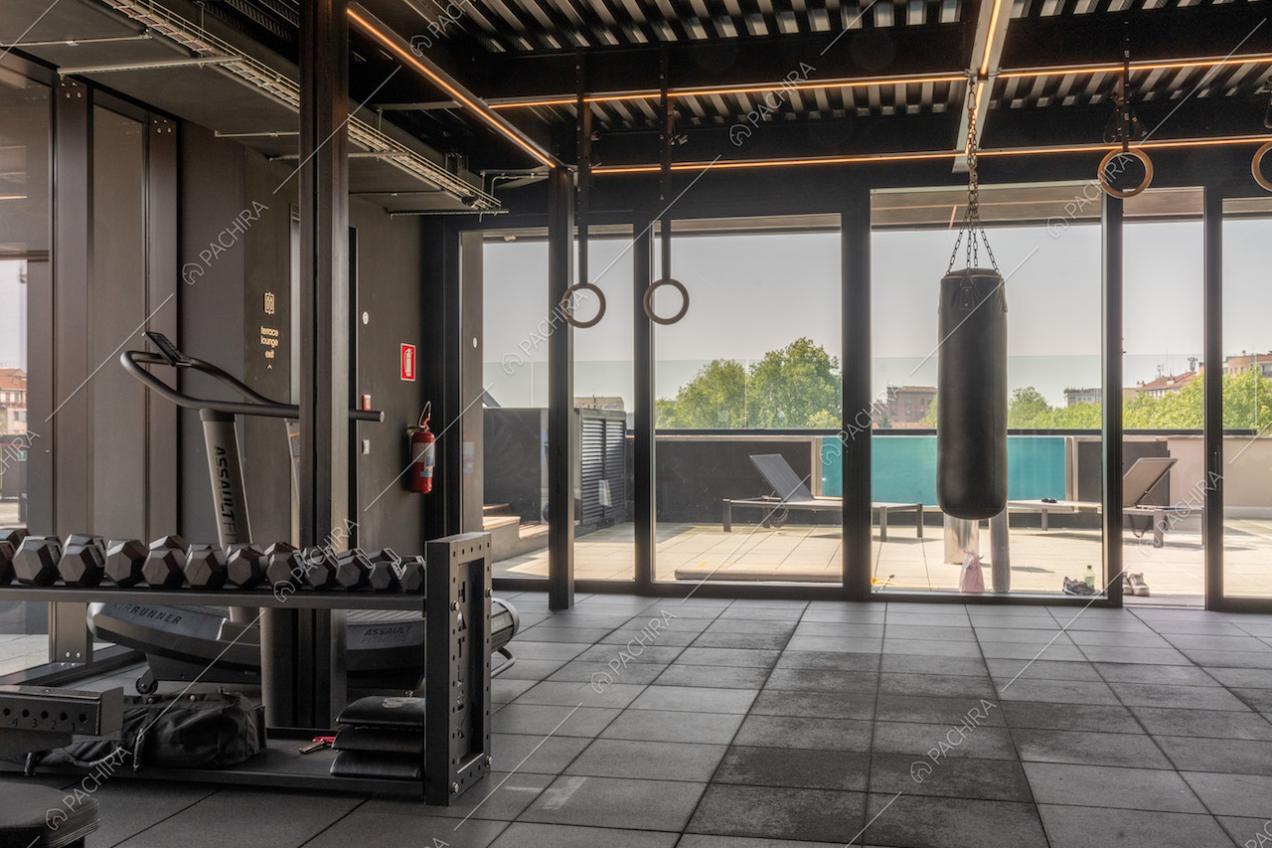 Palestra dell'attico con porte-finestre scorrevoli e vista sulla piscina della terrazza