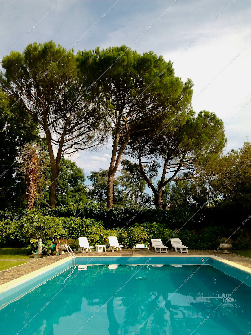 La grande piscina con sedie a sdraio