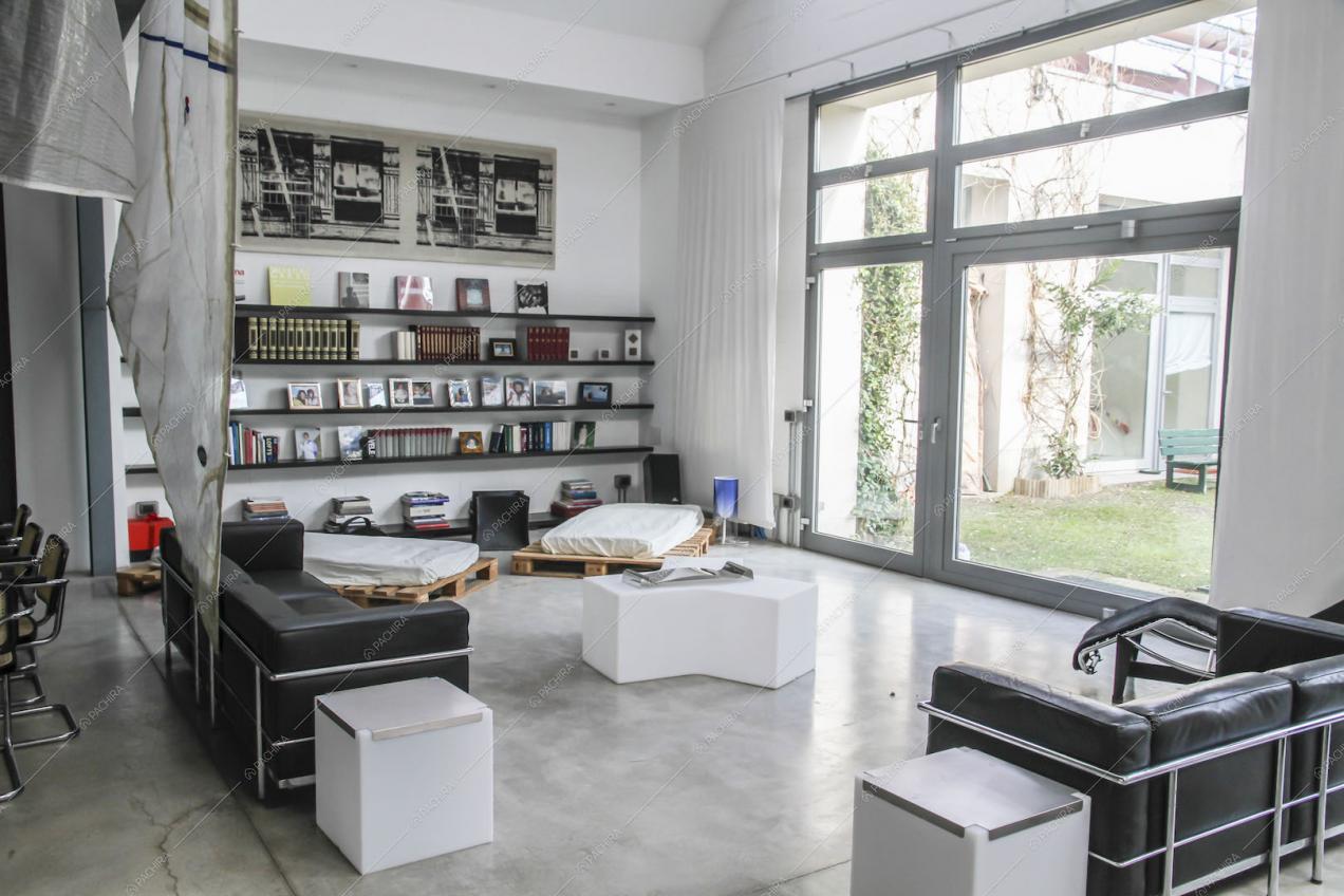 Zona living con divani neri in pelle e vetrate