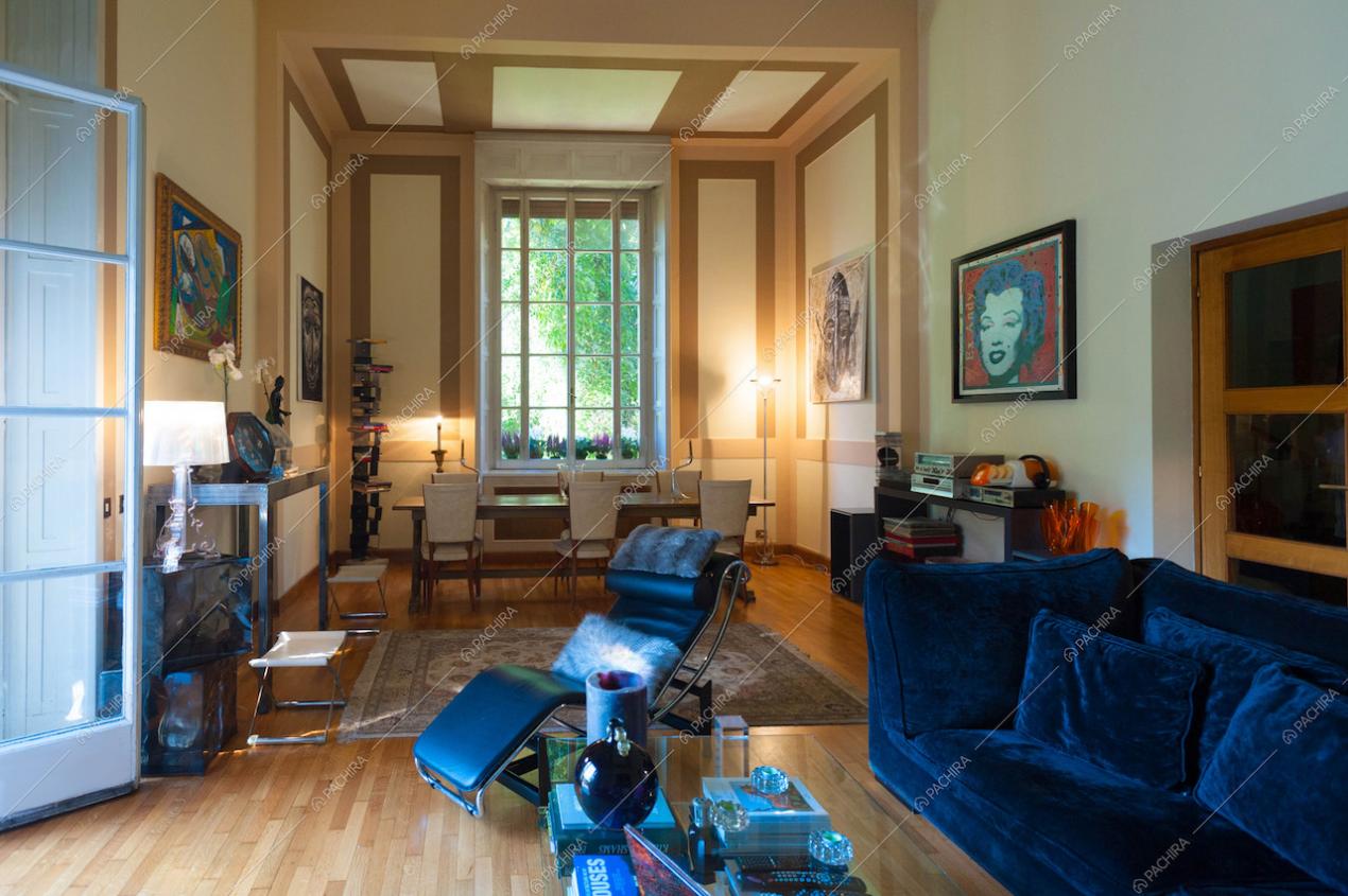 La grande zona living, con divani in velluto blu e poltrona di design