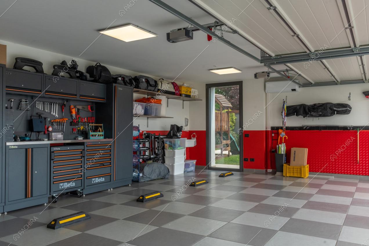 Pavimento a scacchi nell'ampio garage con pareti bianche e rosse