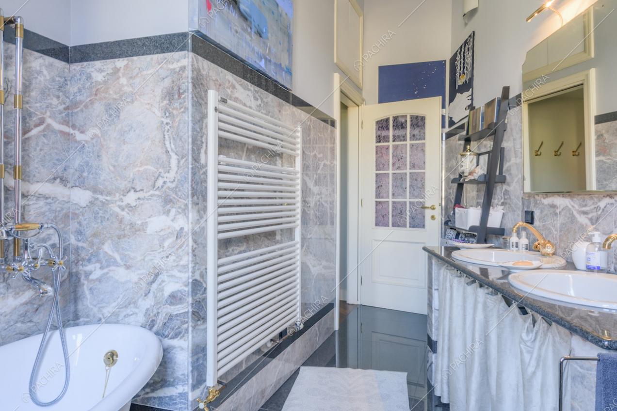 Bagno con pareti rivestite in marmo e lavandini